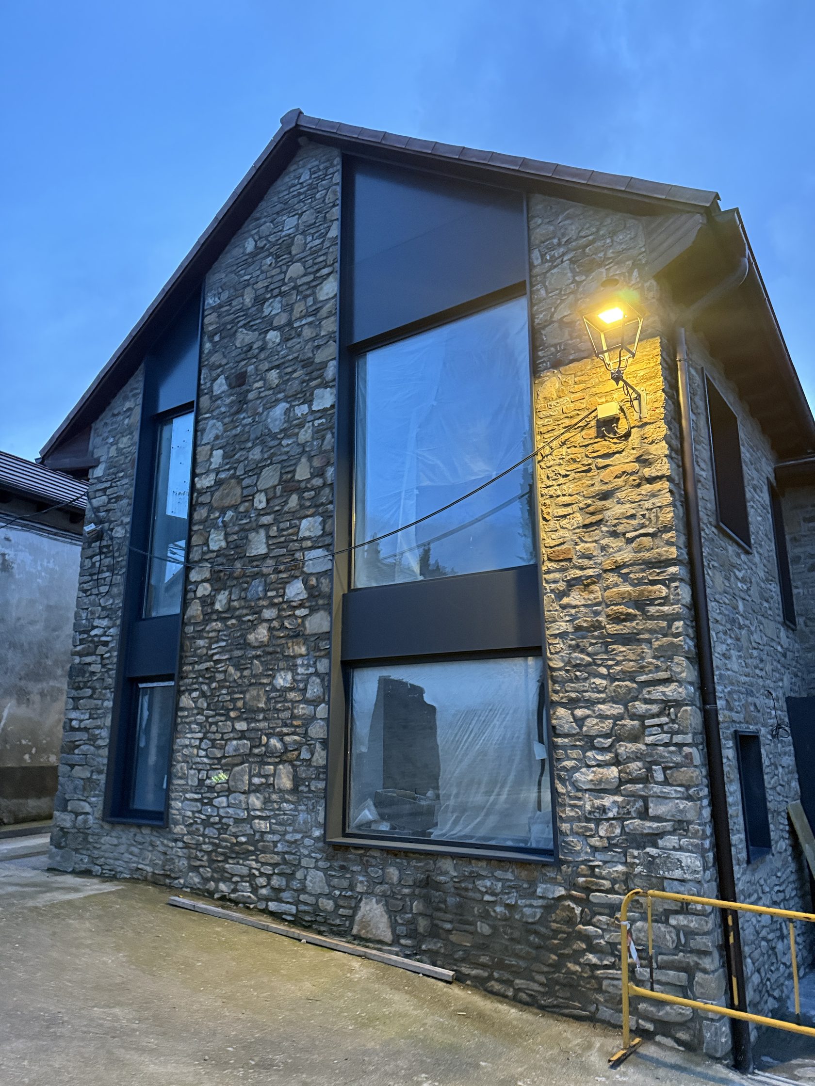 Detalle de la fachada de piedra de la vivienda de Barós al atardecer